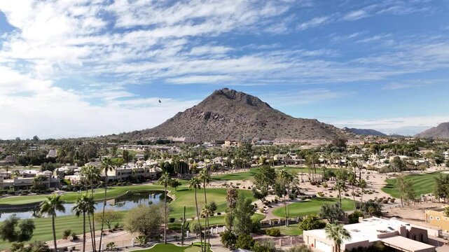 Aerial view of camelback mountain surrounded by residential neighborhoods and desert landscape under a clear blue sky, scottsdale, united states.