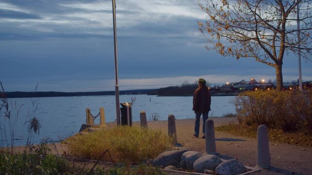 Lonely Woman Walking on Path next to Body of Water in Evening, Peaceful Stroll next to Coast on Cold Autumn Day in Pite&aring;, Sweden, Cozy October Night Alone
