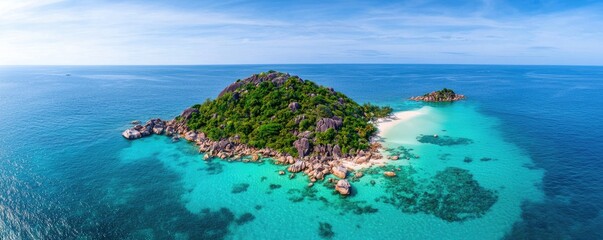Fototapeta premium A stunning aerial view of a tropical island surrounded by turquoise waters, featuring lush greenery and rocky shores under a clear blue sky.