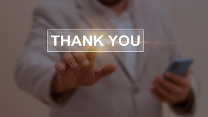 Businessman interacting with a glowing 'Thank You' text, symbolizing gratitude, appreciation, and...