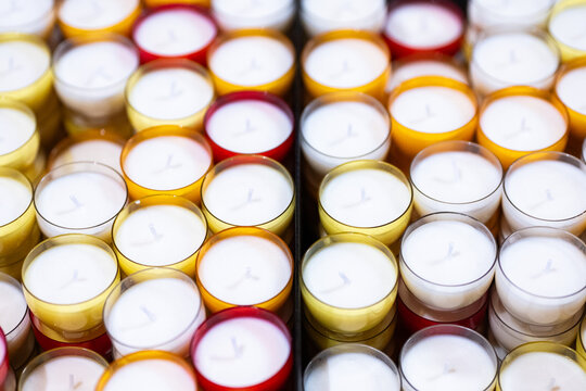 White tealight candles in colorful holders for cozy ambiance