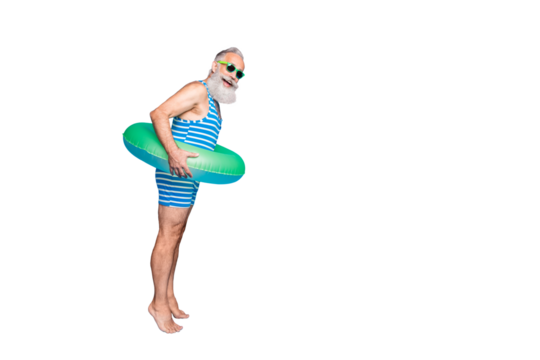 Full length profile side photo of funky grandfather ready to jump hold green lifesaver wear eyeglasses spectacles eyewear striped bathing suit isolated over blue background - Powered by Adobe