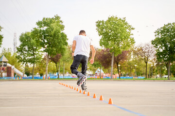 Young man biting an apple while sitting on a park bench