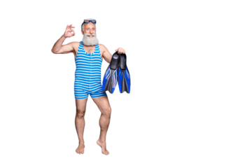Full length photo of retired pensioner holding fins showing ok sign wearing striped bathing suit isolated over blue background