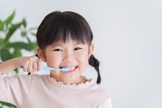 歯ブラシで歯磨きする子供