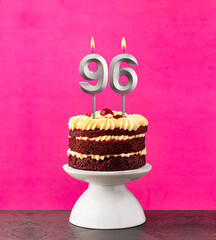 Birthday cake with number 96 candle - Red velvet on a fuchsia background.