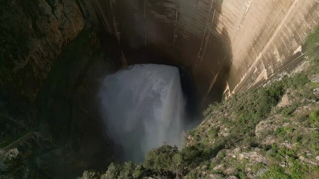 Howell Bunger valve in operation in vault dam. Dam releasing water. Aerial view of water outlet from the dam. Quentar Reservoir. Spain.
