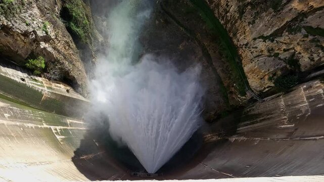 Dam releasing water. Slow motion overhead view of water outlet from the dam. Howell Bunger valve in operation in vault dam. Quentar Reservoir. Spain.