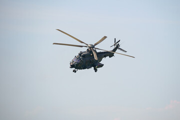 A military helicopter in the sky at an airshow.