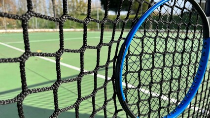 close-up of a tennis net and tennis racket