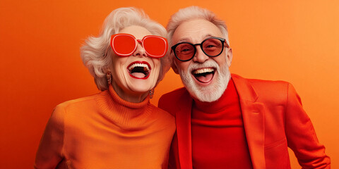 Happy smiling senior wearing sunglasses, orange solid colorful background, image with space for text / Femme âgée souriante et heureuse avec lunettes de soleil, fond orange, espace pour le texte