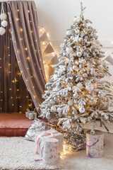 A Christmas tree sprinkled with artificial snow and a tent decorated with a luminous garland in the New Year's interior. Background for New Year wallpapers and postcards.