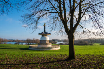 A serene January morning frames the Peace Pagoda, a solitary leafless tree, and the tranquil expanse of North Willen Lake in the distance