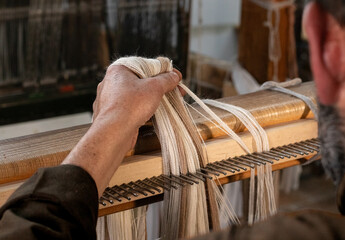Hand of Hispanic artisan - handcraft  weaving fabric on loom