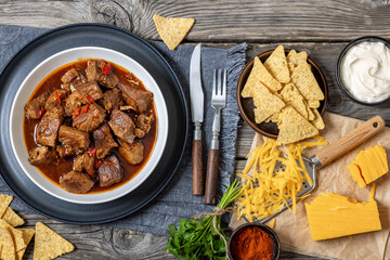 beef stew in a white bowl on rustic wooden table
