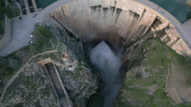 Dam discharges water from the reservoir. Aerial view of water realising from the dam. Howell Bunger valve in operation in vault dam. Quentar Reservoir. Spain.