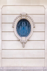 An Ornate Oval Window With A Decorative Iron Grille Set In A Historic Building Facade. The Elegant...
