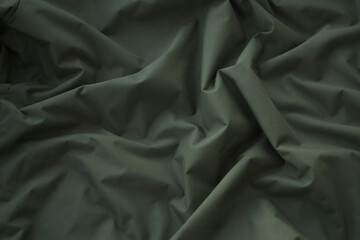 Texture of Dark green military uniform textile cloth with folds