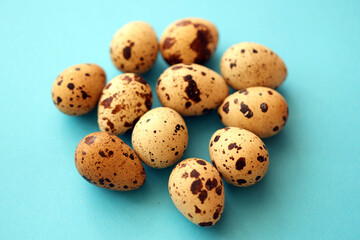 Obraz premium Few amount of quail eggs in small pile on blue background