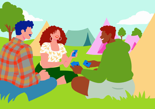 Friends sitting and plying cards at park