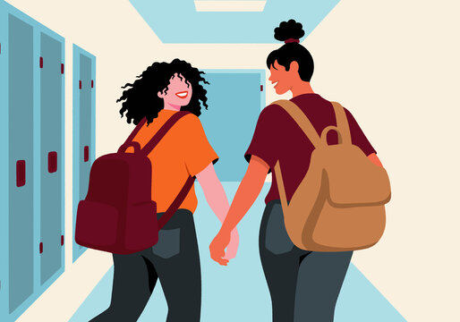Young women holding hands and walking in college corridor