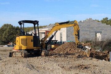 Obraz premium Mini pelle devant la maison en construction
