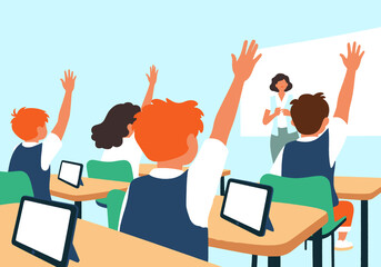 School children raising hands with teacher in classroom