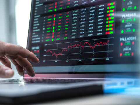 Trader working over graph of stock market on laptop