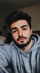 Fototapeta premium A phone photograph of an attractive man, wearing a grey hoodie and smiling at the camera