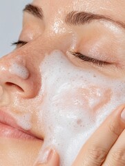 Fototapeta premium Close-Up of a Woman's Face Being Gently Cleansed with Foam