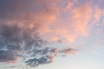 Obraz premium Exotic sunset and soft pink clouds of pastel tones. Scenic image of textured sky. Perfect summertime wallpaper. Dramatic evening light and fiery orange sunset. Beauty of earth. High quality photo