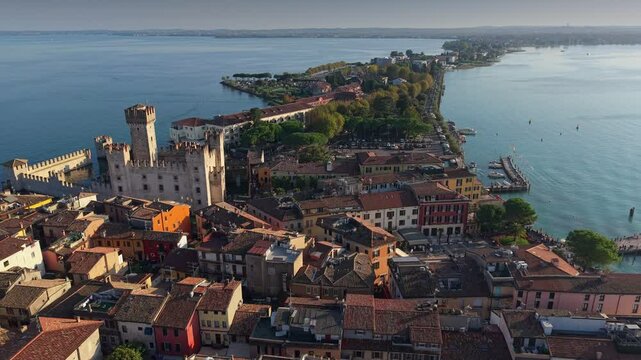 Architecture and serene waters in Sirmione, Italy, highlighting the stunning lakeside. Aerial view of Sirmione castle on Garda lake at sunset