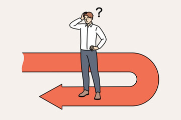 Frustrated businessman has fallen victim to crisis and is forced to move backwards to avoid bankruptcy, scratching head. Sad manager stands on red arrow back symbolizing recession and crisis © Dzianis Vasilyeu