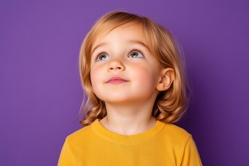 Naklejka premium Amazed little girl looks up with wonder; expressive childhood moment on purple background; vibrant colors 