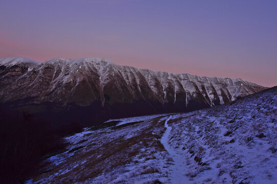 tramonto quasi notte sul Morrone in Abruzzo con neve su cime e sentiero da percorrere con le ciaspole