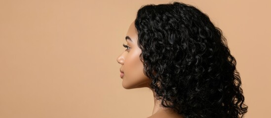 Profile view of a woman with curly hair against a neutral background