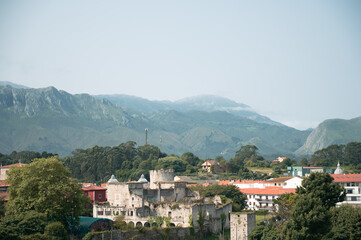 Obraz premium Urban landscape of Llanes, Asturias, with a castle in mountains