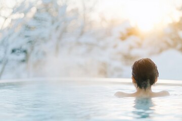 Fototapeta premium Back view of woman in winter hot pool at sunrise.