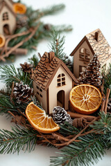 christmas arrangement centerpiece close-up with dried oranges, cinnamon and pine branches around little wooden houses