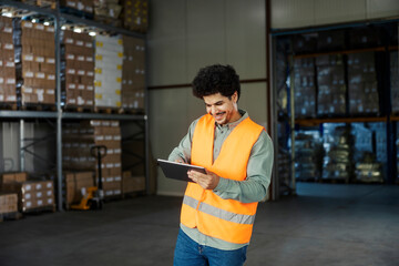 Happy interracial storage manager scrolling on tablet and going trough checklist.