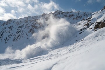 Fototapeta premium Avalanche cascading down the mountain slope during winter in a remote alpine region