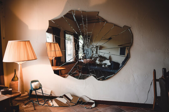 Espejo roto colgado de la pared. Generado con IA