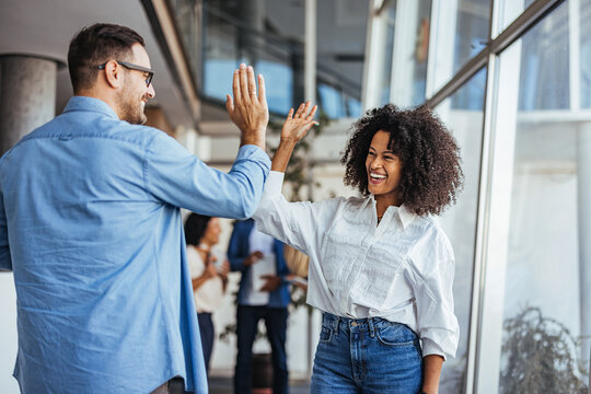 Colleagues Celebrating Success With a High Five in the Office