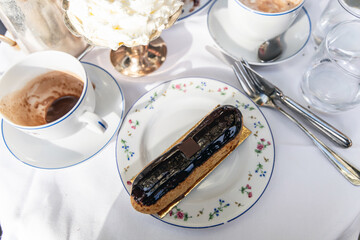 French eclair on a plate on a table in a restaurant in Paris, France