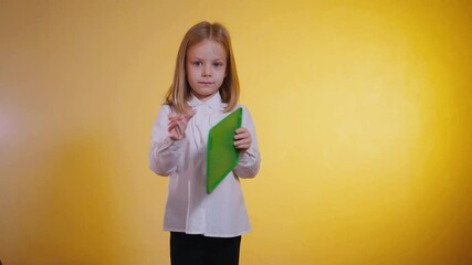 Smiling expression of a girl, capturing ideas on a green tablet. Happy young artist, diligently creating on a vibrant green tablet. A child engrossed in digital art. White shirt, focused gaze,