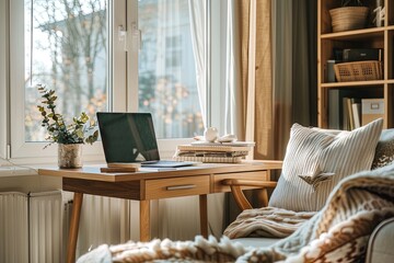 Cozy home office setup by window with laptop and books in natural light