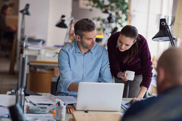 Obraz premium Young man and woman working together on a project in a startup company office