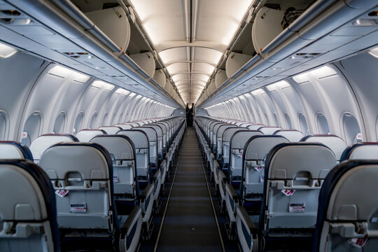 Vista trasera de los asientos y pasillo de un avi&oacute;n de pasajeros vac&iacute;o. Generado con IA