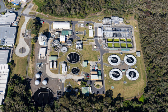 Aerial view of modern water treatment plant with tanks and surrounding forest, Warana, Australia.