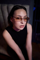 A stylish woman struts into the bar at night, exuding elegance and seduction of nightlife